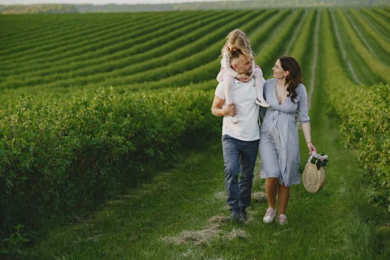 A joyful family strolls together in a beautiful green vineyard, capturing moments of love and togetherness.